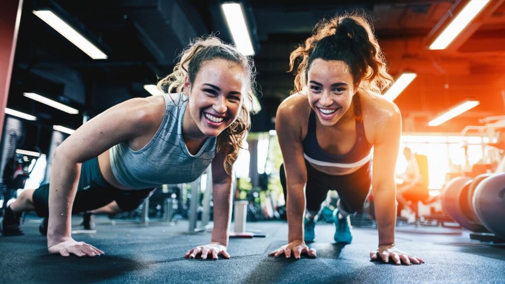 Two friends working out together, laughing and having fun